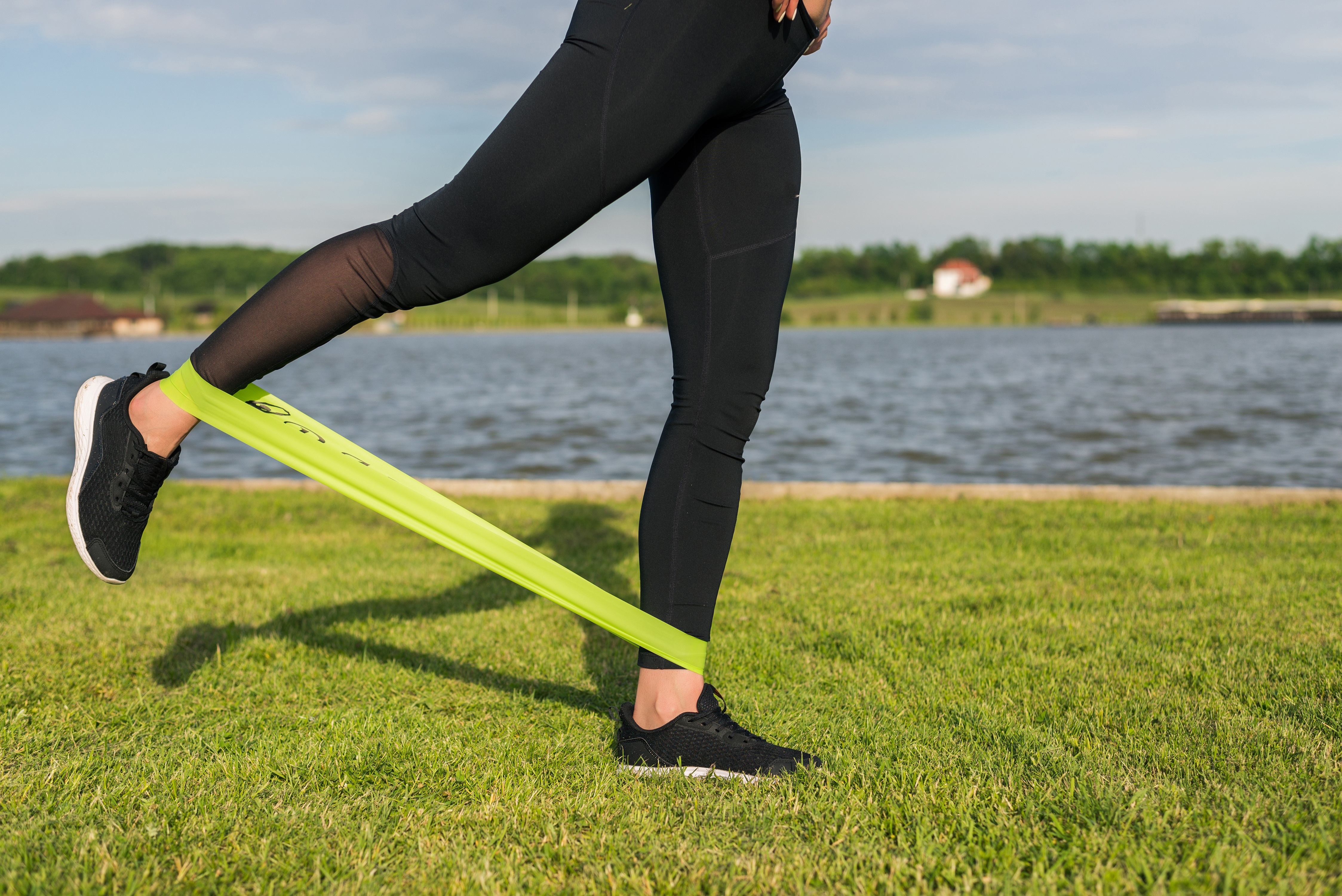 athletic woman workout with resistance band outdoors.
